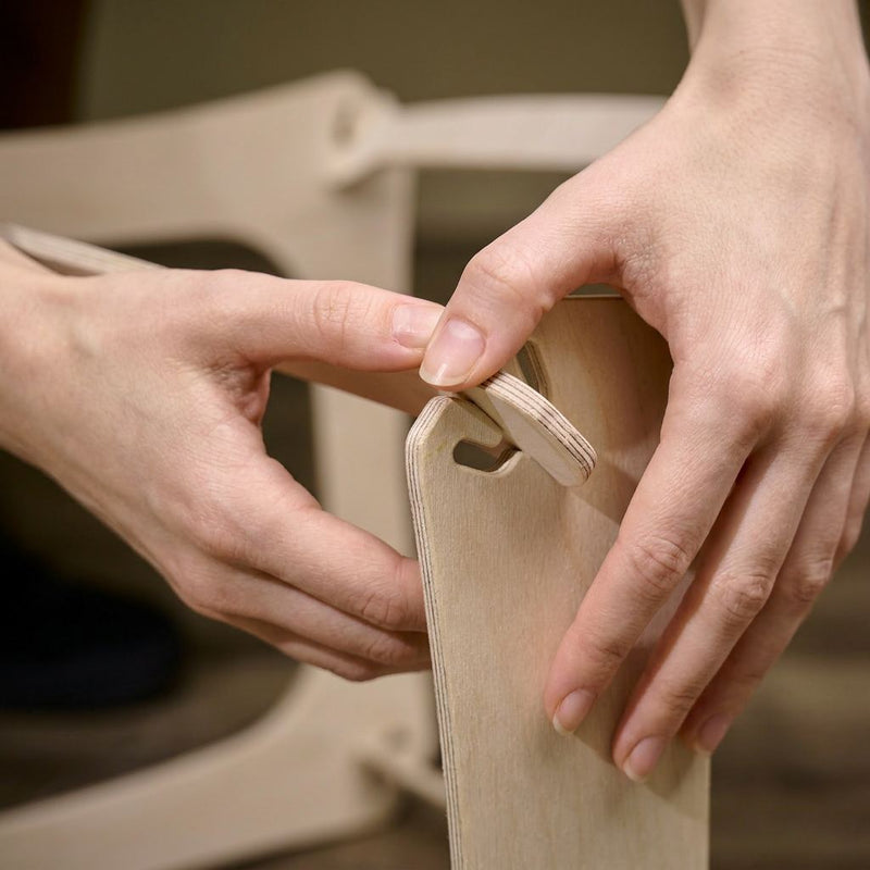 Hands snapping two birch plywood panels together